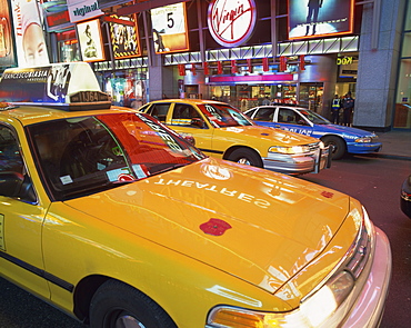 Yellow cabs on the street at night in Times Square, with Virgin Megastore in the background, in New York, United States of America, North America