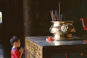 Boy praying at Kek Lok Si Temple, Penang, Kuala Lumpur, Malaysia, Asia