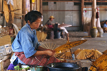 Woman making umbrellas with brown paper at the Umbrella factory at Bo Sang, Chiang Mai, Thailand, Southeast Asia, Asia