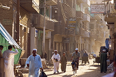 Street scene with man on bicycle and man pushing handcart, Luxor, Thebes, Egypt, North Africa, Africa