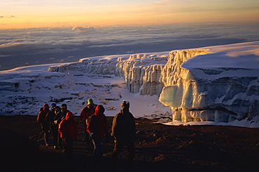 Trekkers and glacier at sunrise on summit of Kibo, 5895m, Kilimanjaro National Park, Tanzania, East Africa, Africa