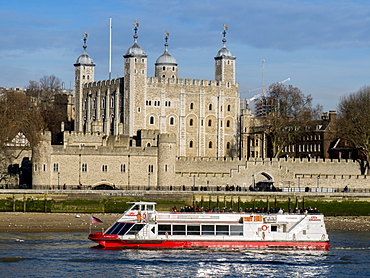 Tower of London, UNESCO World Heritage Site across the River Thames with tour boat, London, England, United Kingdom, Europe