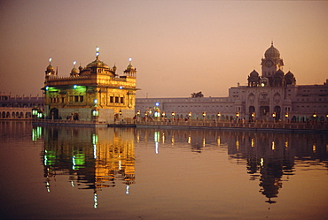 Dusk over the Holy Pool of Nectar looking towards the clocktower and the Golden Temple, Sikh holy place, Amritsar, Punjab State, India, Asia