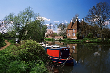 Brightly painted barge and oast houses on the River Medway, Yalding, near Maidstone, Kent, England, United Kingdom, Europe