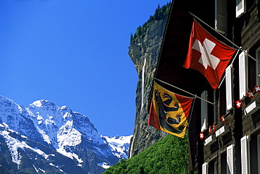 Snow-capped peaks, the Staubbach falls and flags of Bern and Switzerland, Lauterbrunnen, Bern, Switzerland, Europe