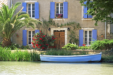 Boat moored alongside house on the bank of the Canal du Midi, Le Somail, Aude, Languedoc Roussillon, France, Europe