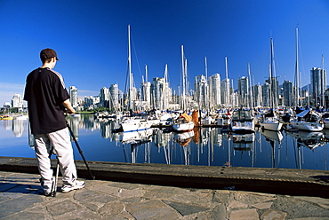 Photographer at False Creek marina, with downtown skyscrapers behind, Vancouver, British Columbia (B.C.), Canada, North America