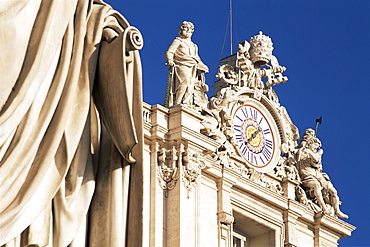 Clock adorning facade of St. Peter's Basilica, with statue of St. Peter in front, Piazza  San Pietro, St. Peters, Vatican City, Rome, Lazio, Italy, Europe