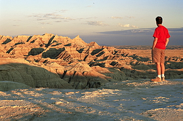 Visitor looking over rugged landscape from the Badlands Loop Road near Panorama Point, Badlands National Park, South Dakota, United States of America, North America