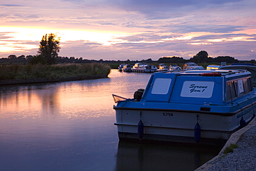 Pleasure boats moored on the River Ant, sunset, Norfolk Broads, Ludham, Norfolk, England, United Kingdom, Europe