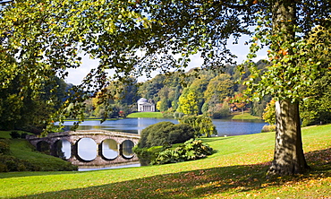 View across lake to the distant Pantheon in autumn, with Palladian bridge, Stourhead, near Mere, Wiltshire, England, United Kingdom, Europe