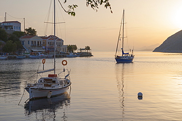 View across the tranquil harbour, sunrise, Gialos (Yialos), Symi (Simi), Rhodes, Dodecanese Islands, South Aegean, Greece, Europe