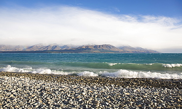 View from rocky shoreline across the stormy waters of Lake Pukaki, near Twizel, Mackenzie district, Canterbury, South Island, New Zealand, Pacific