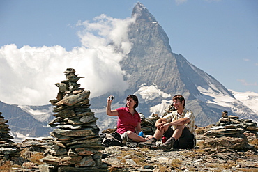 Two hikers resting in front of the Matterhorn, Zermatt, Valais, Swiss Alps, Switzerland, Europe