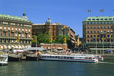 Sightseeing boat and waterfront hotels and cafes in the city centre of Stockholm, Sweden, Scandinavia, Europe