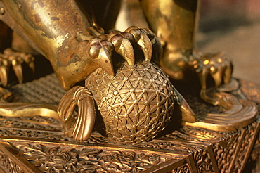 Close-up of the paw of a gilt bronze lion holding a fire ball, symbol of force, in the Forbidden City in Beijing, China, Asia