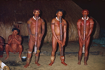 A group of Yawalapiti Indians playing Jabui flutes at night in Brazil, South America