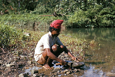 Hua Ulu man sharpening knife, Seram, Moluccas, Indonesia, Southeast Asia, Asia