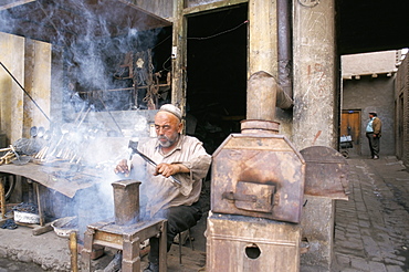 Blacksmith at work, Sunday market, Kashi, Xinjiang, China, Asia