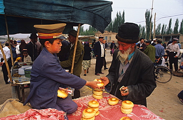 Buying bagel-like rolls, Sunday Market, Kashgar, Xinjiang, China, Asia