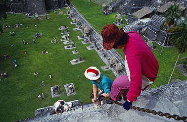 Tourist climbing down front of Temple One, Tikal, UNESCO World Heritage Site, Guatemala, Central America