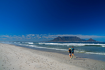 Joggers running on Blouberg Beach in the early morning, with Table Mountain in the background, Cape Town, South Africa, Africa