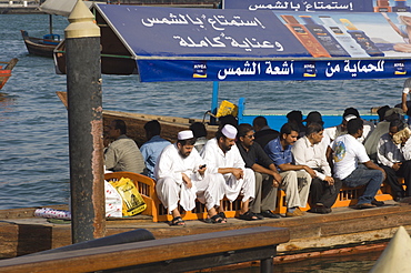 Passangers on an abra, the small ferries that cross Dubai Creek, Dubai, United Arab Emirates, Middle East