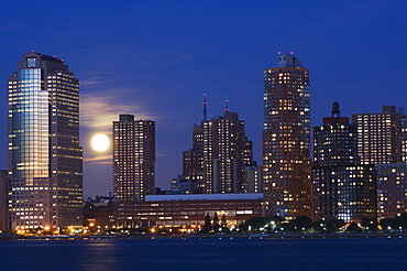 Full moon rising over Lower Manhattan skyline across the Hudson River, New York City, New York, United States of America, North America