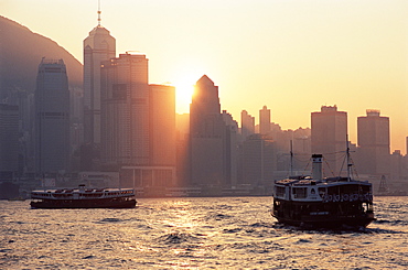 Star ferries, Victoria Harbour and Hong Kong Island skyline at sunset, Hong Kong, China, Asia