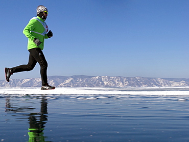 Runner in the 10th Baikal Ice Marathon, run on the frozen surface of the world's largest fresh water lake on 1st March 2014, Siberia, Irkutsk Oblast, Russia, Eurasia