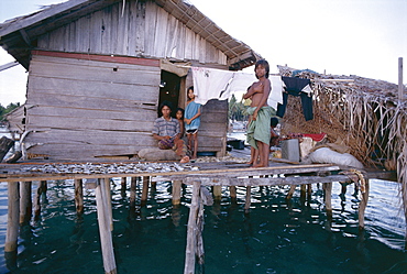 Bajau family in stilt house over the sea, with fish drying on platform outside, Sabah, island of Borneo, Malaysia, Southeast Asia, Asia