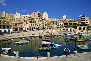 Boats and buildings on the waterfront at St. Julians Bay on the island of Malta, Mediterranean, Europe