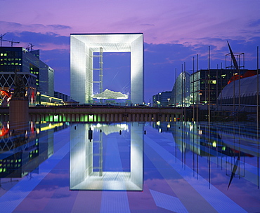 La Grande Arche illuminated at dusk, seen from across the ornamental lake, La Defense, Paris, France, Europe