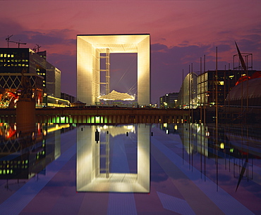 La Grande Arche illuminated at dusk, seen from across the ornamental lake, La Defense, Paris, France, Europe