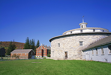 Circular building with houses in the background at the Hancock Shaker Village, in Massachusetts, New England, United States of America, North America