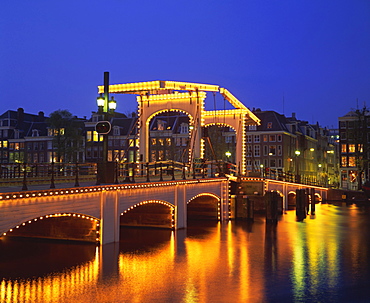 Magere Bridge illuminated in the evening, Amsterdam, Holland (The Netherlands), Europe