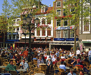 Tourists and locals at an open air cafe in Leidseplein, Amsterdam, Holland, Europe