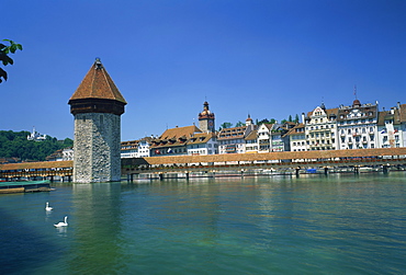 The Chapel Bridge and Water Tower with the city of Lucerne beyond, Switzerland, Europe