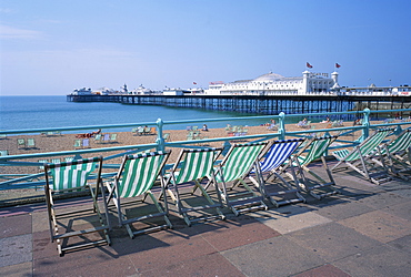 Deckchairs above the beach and the Palace Pier at Brighton, Sussex, England, United Kingdom, Europe