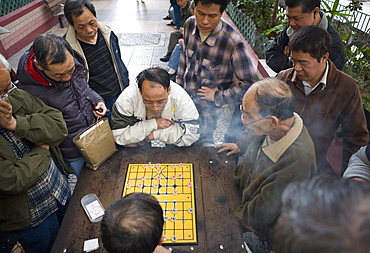 Two Chinese men playing Chinese Chess in the street, other men watching, Hong Kong, China, Asia