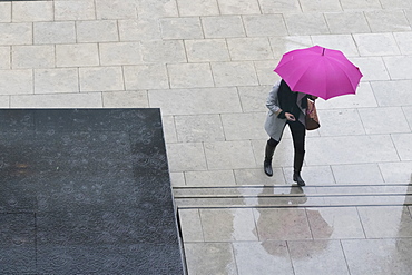 Woman with umbrella and mobile phone walking up steps to Auckland Art Gallery, Auckland, North Island, New Zealand, Pacific