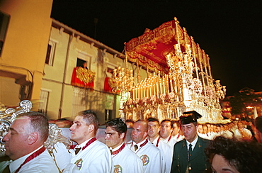 Malaga-Spain - Easter Week (Semana Santa) - Members of a brotherhood carrying a religious float in procession 