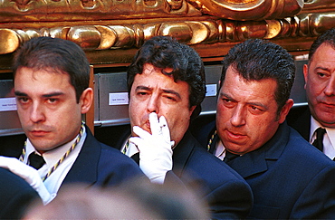 Malaga-Spain - Easter Week (Semana Santa) - A brotherhood member manages a smoke while helping to carry a float in procession on Palm Sunday 