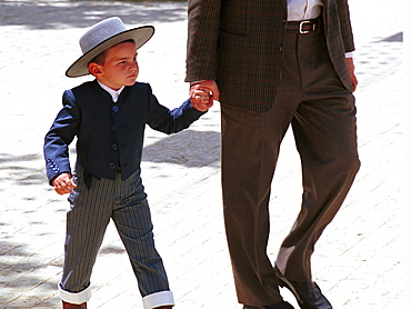 Seville - Spain - The Feria de Abril - Seville Fair - A boy in traditional costume is guided around the fair site 