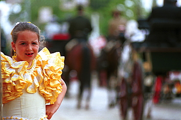 Seville - Spain - The Feria de Abril - Seville Fair - A girl in traditional costume watching the carriage parade 