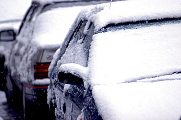 Street scene with snow on cars at dusk during winter, England, United Kingdom, Europe