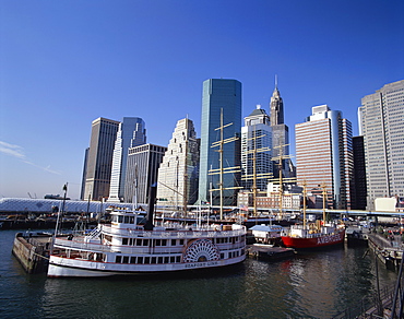 Boats in the harbour at South Street Sea Port, with the city skyline in the background, in New York, United States of America, North America