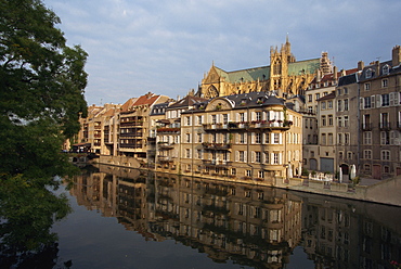 Reflections in water of buildings, with the Cathedral of St. Etienne in the background, in the town of Metz, Lorraine, France, Europe