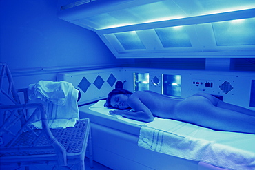 Women lying naked on sunbed