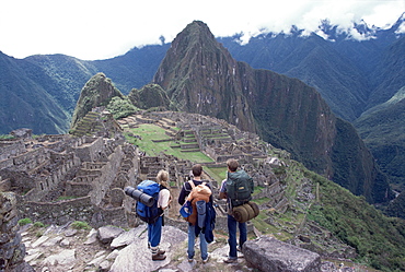 Backpackers at the Inca ruins of Machu Picchu, with Huayna Picchu in background, Peru, South America